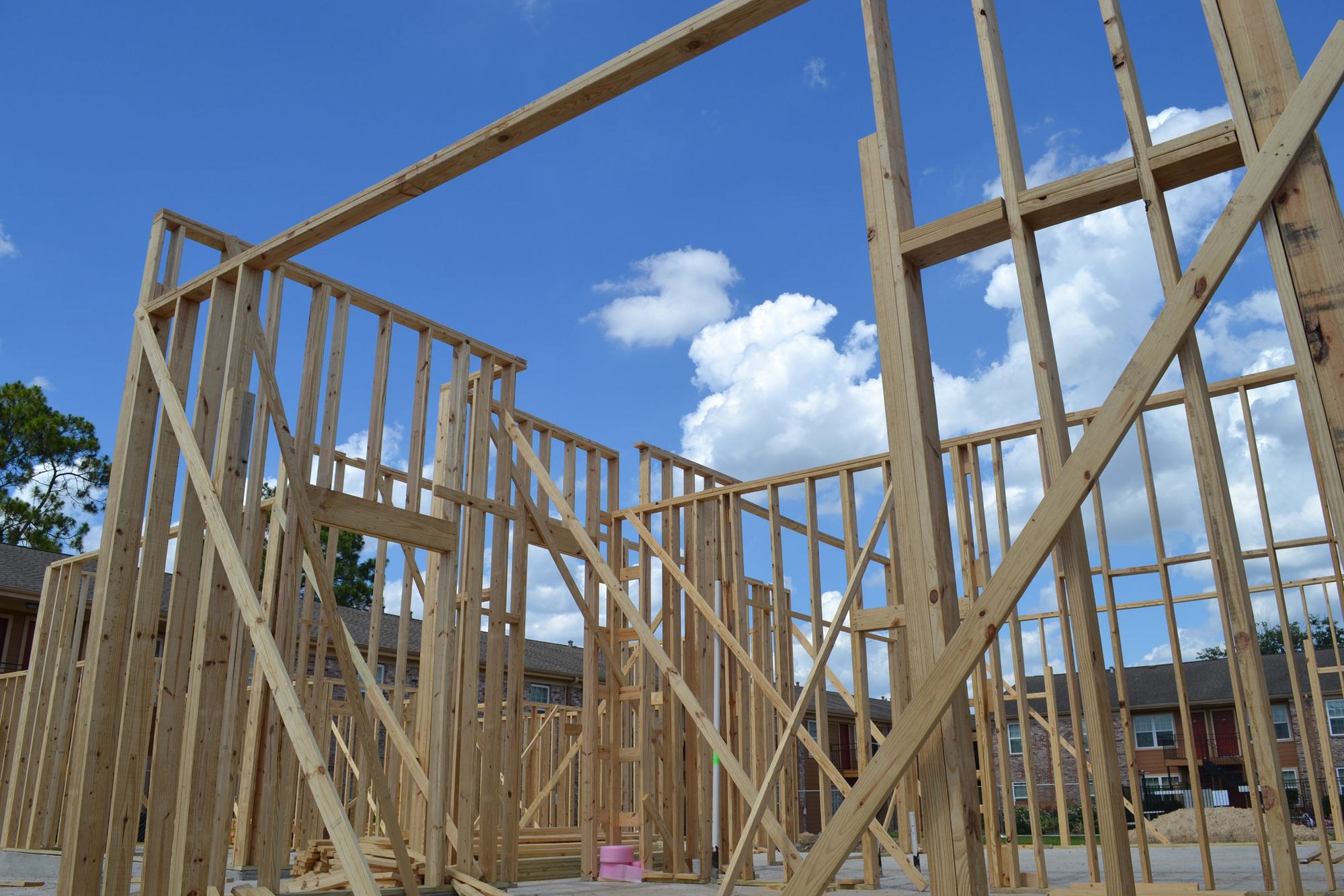 New wood framing rising against a blue sky